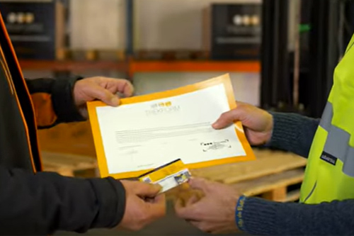 Formador del curso de carretillas elevadroas Trekform entregando documentación de la realización del curso de carretillas elevadoras.