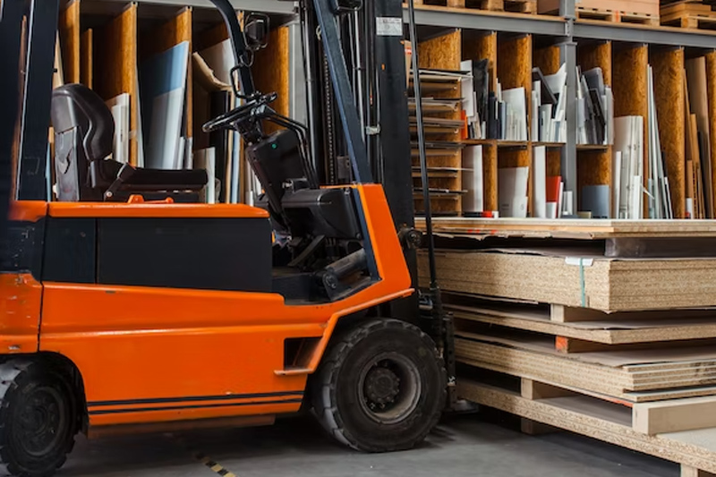 Carretilla elevadora cargada con láminas de madera en almacén carpintería.